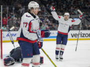 Washington Capitals right wing T.J. Oshie (77) and center Hendrix Lapierre react after Oshie's goal against Seattle Kraken goaltender Joey Daccord during the second period of an NHL hockey game Thursday, March 14, 2024, in Seattle.