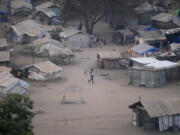 FILE - People stand by their houses in Juba, South Sudan, on Feb. 5, 2023. South Sudan’s government is closing down all schools starting Monday as the country prepares for a wave of extreme heat expected to last two weeks. The health and education ministries advised parents to keep all children indoors as temperatures are expected to soar to 113 Fahrenheit, in a statement late Saturday.