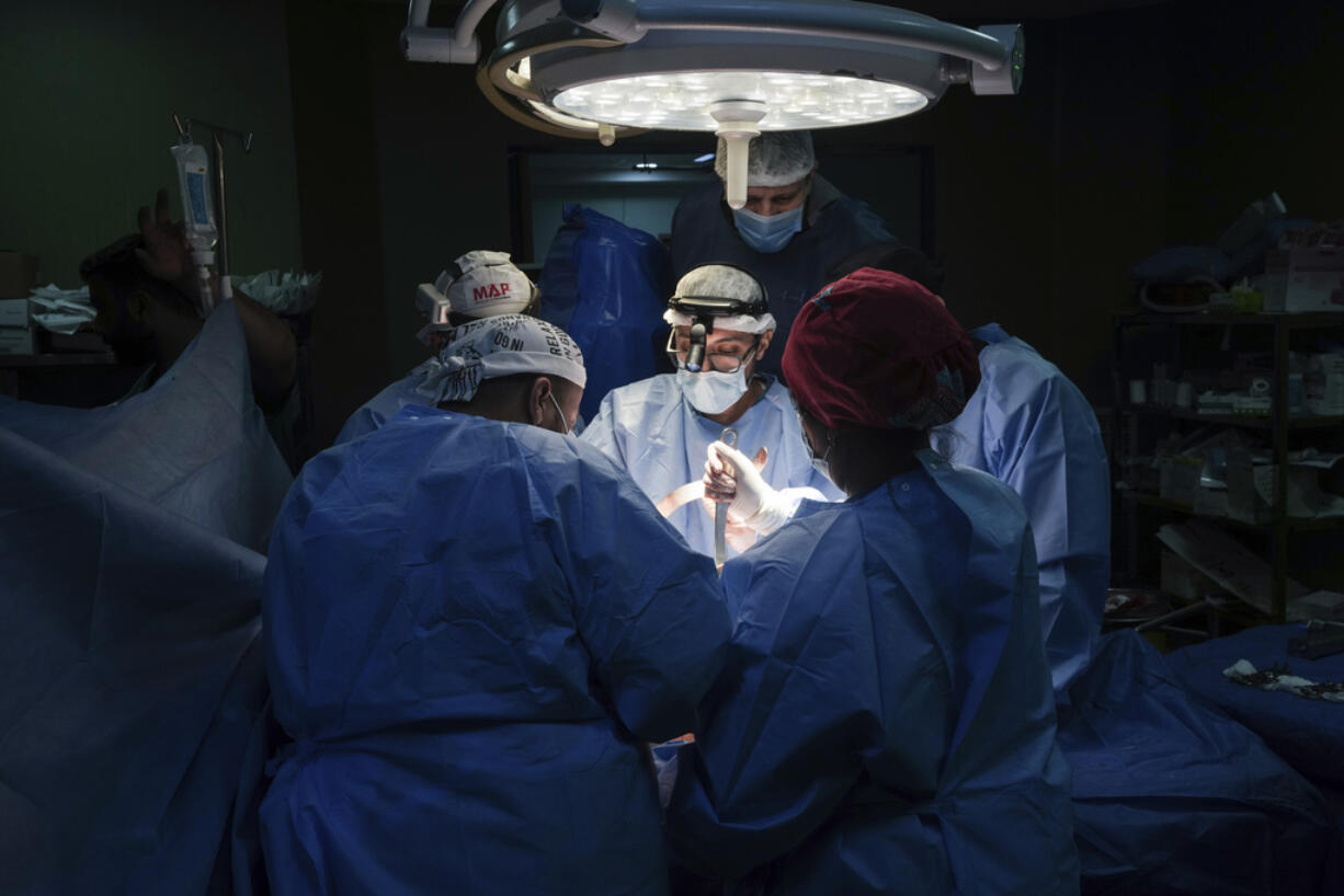 Doctors perform surgery on a patient at Al-Aqsa Martyrs Hospital, in Deir al-Balah, central Gaza, Sunday, March 17, 2024. An international team of doctors has been working the past two weeks at the facility amid shortages of supplies.