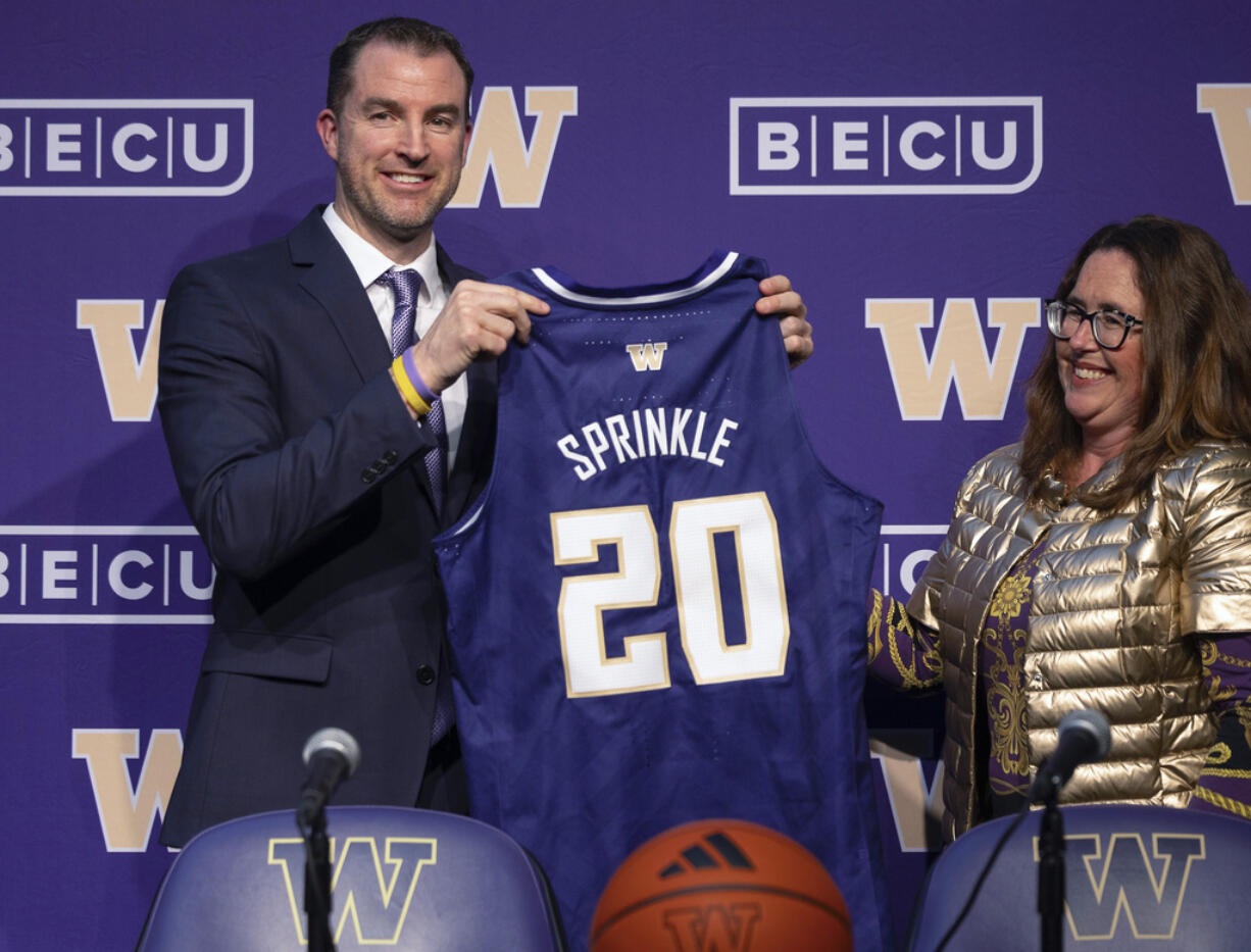 Washington deputy athletic director Erin O'Connell, right, introduces men's basketball coach Danny Sprinkle, Wednesday, March 27, 2024, in Seattle.