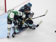 Dallas Stars left wing Jamie Benn, left, is tangled up with Seattle Kraken defenseman Jamie Oleksiak, center, and goaltender Joey Daccord, right, near the Kraken goal during the first period of an NHL hockey game Saturday, March 30, 2024, in Seattle.