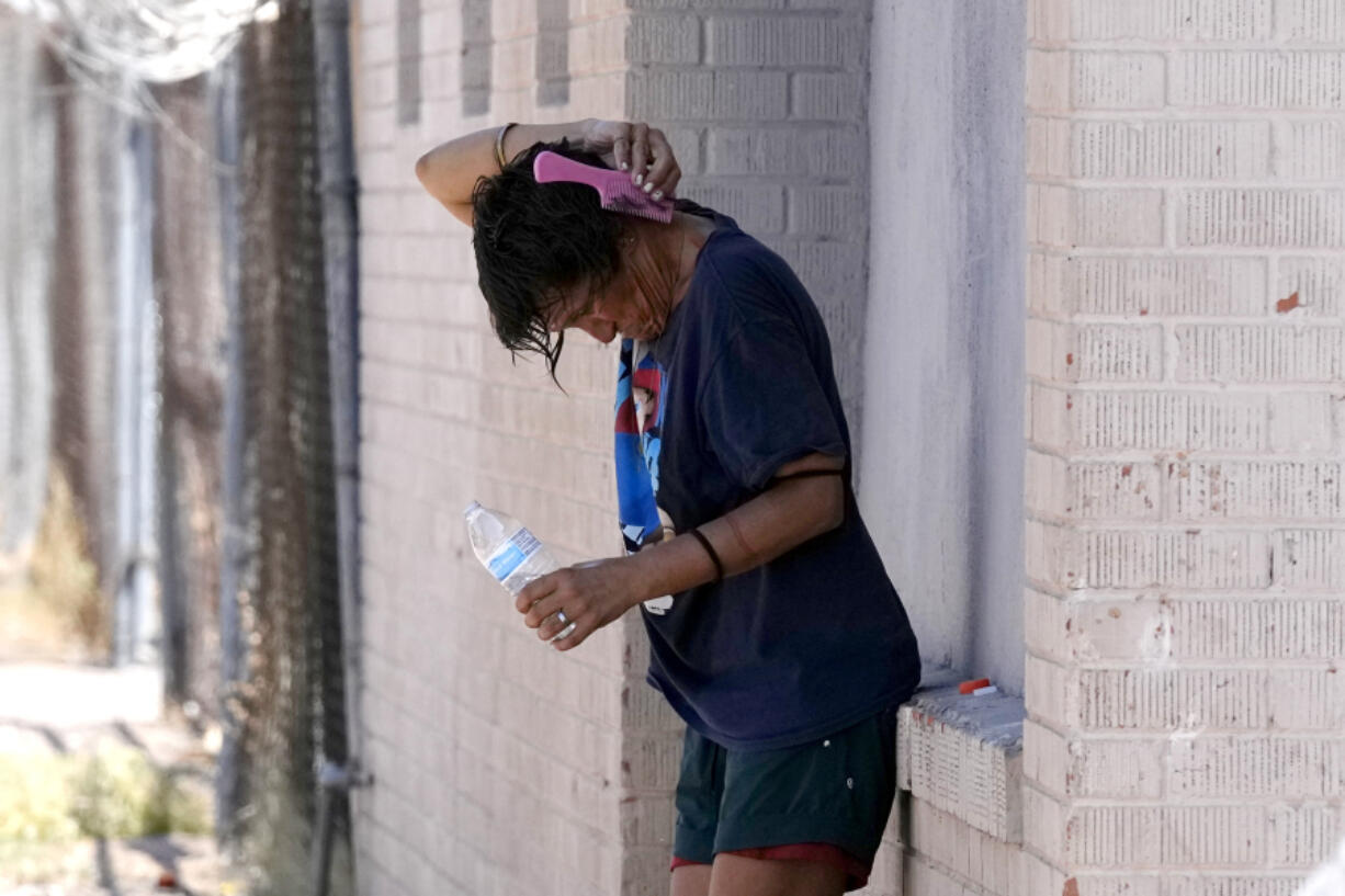 FILE - A person tries to cool off in the shade as temperatures are expected to hit 116-degrees Fahrenheit, Tuesday, July 18, 2023, in Phoenix. Arizona&rsquo;s health department has named a physician to address ways to lessen the effects of extreme heat in the arid Southwestern state as the first statewide heat officer in the nation. (AP Photo/Ross D.