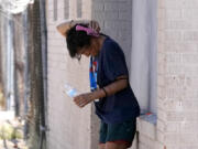 FILE - A person tries to cool off in the shade as temperatures are expected to hit 116-degrees Fahrenheit, Tuesday, July 18, 2023, in Phoenix. Arizona&rsquo;s health department has named a physician to address ways to lessen the effects of extreme heat in the arid Southwestern state as the first statewide heat officer in the nation. (AP Photo/Ross D.