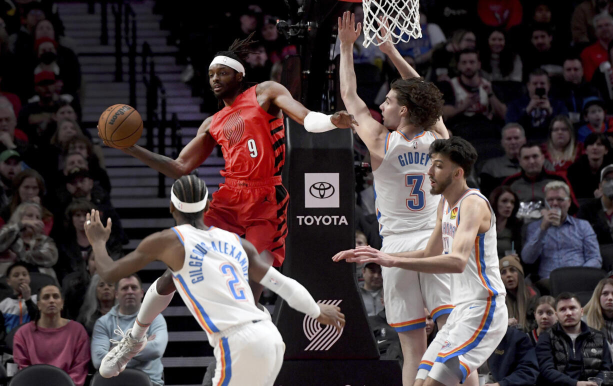 Portland Trail Blazers forward Jerami Grant, second form left, looks to pass the ball as Oklahoma City Thunder guard Shai Gilgeous-Alexander, left, guard Josh Giddey, second from right, and forward Chet Holmgren, right defend during the first half of an NBA basketball game in Portland, Ore., Wednesday, March 6, 2024.