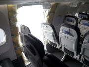 FILE - This photo released by the National Transportation Safety Board shows a gaping hole where the paneled-over door had been at the fuselage plug area of Alaska Airlines Flight 1282, Jan. 7, 2024, in Portland, Ore. More passengers who were aboard an Alaska Airlines Boeing 737 jet when part of its fuselage blew out are suing. The latest lawsuit, representing seven passengers, was filed in Washington&rsquo;s King County Superior Court Thursday, March 14, 2024, against Boeing, Alaska Airlines, Spirit AeroSystems and 10 people listed as John Does.