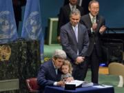 FILE - U.S. Secretary of State John Kerry holds his granddaughter as he signs the Paris Agreement on climate change, April 22, 2016 at U.N. headquarters.