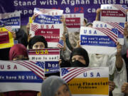 FILE - Afghan refugees hold placards during a gathering in Islamabad, Pakistan, July 21, 2023. Senators from both parties are urging congressional leaders to ensure that more visas are made available to Afghans who worked alongside U.S. troops in America&rsquo;s longest war. The senators say an additional 20,000 visas are needed before the end of the fiscal year in September.