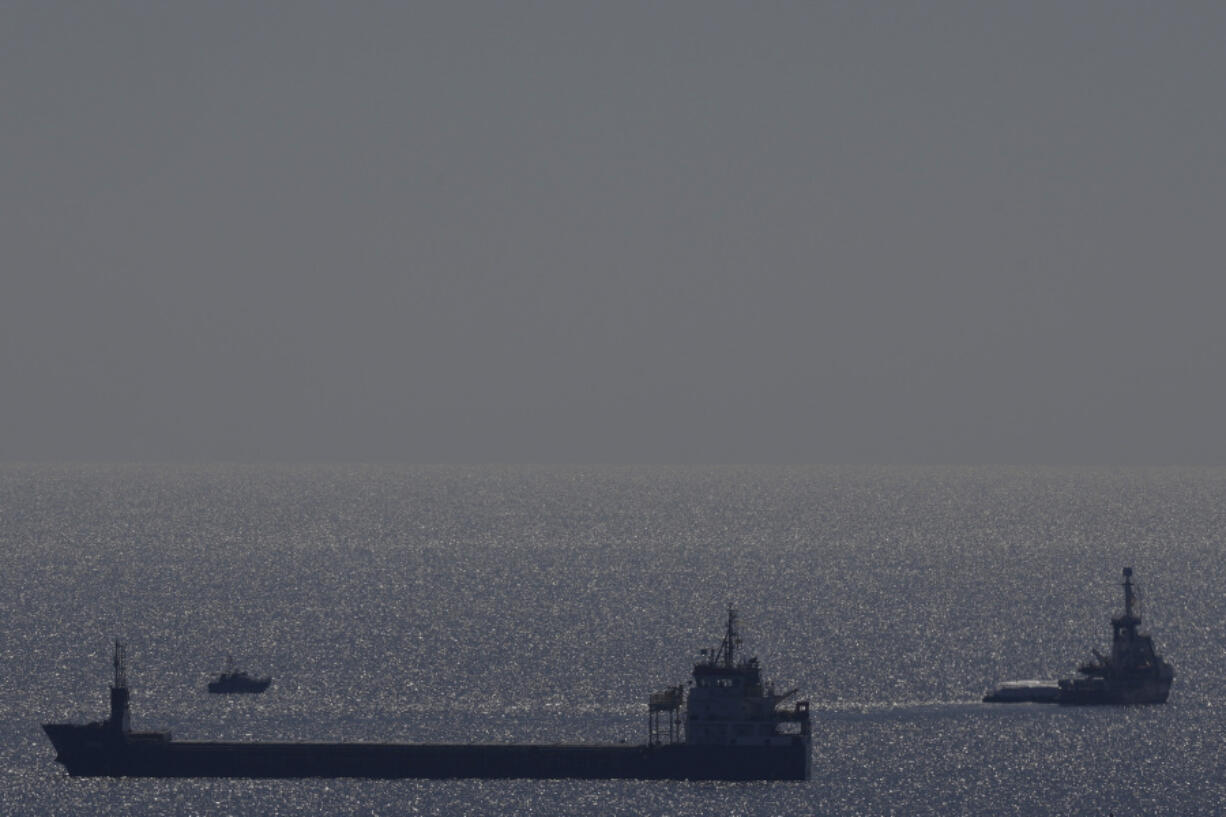 The ship, right, belonging to the Open Arms aid group with aid on a platform ferry some 200 tonnes of rice and flour directly to Gaza, departs from the port of southern city of Larnaca, Cyprus, Tuesday, March 12, 2024. An aid ship loaded with some 200 tons of food set sail Tuesday from Cyprus to Gaza, the international charity behind the effort said. The shipment is a test for the opening of a sea corridor to supply aid to the territory, where starvation is spreading five months into the Israel-Hamas war.