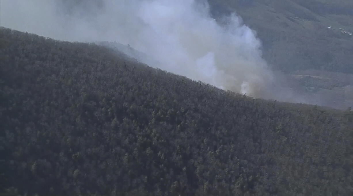 Smoke fills the sky from a wildfire in Shenandoah National Park near Luray, Va. on Thursday, March 21, 2024.  Officials say crews are battling scores of wildfires around Virginia, including a fire affecting hundreds of acres at Shenandoah National Park.