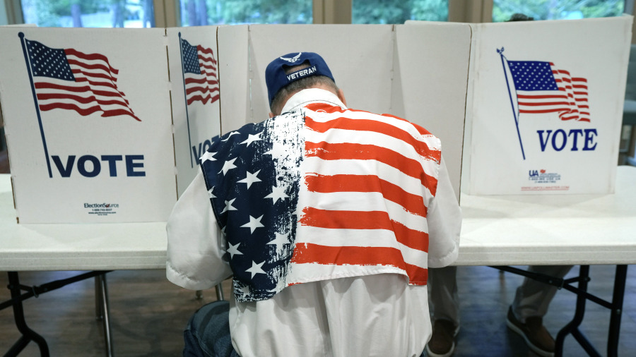 FILE - A patriotic voter sits at a voting kiosk and selects his choices in a party primary in Jackson, Miss., Tuesday, Aug. 8, 2023. Super Tuesday put former President Donald Trump within reach of clinching his third consecutive Republican presidential nomination. But it may be Republican voters in Georgia, Hawaii, Mississippi and Washington who put him over the top. President Joe Biden is also competing in presidential contests that day, but the earliest he can clinch his party&#039;s nomination is a week later on March 19. (AP Photo/Rogelio V.