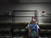 Election worker Wendy Wimer looks through vote-by-mail ballots during the presidential primary election on Tuesday, March 12, 2024, at the Clark County Elections Office in Vancouver, Wash.