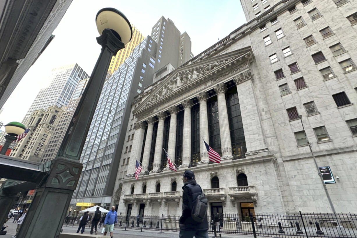 People pass the New York Stock Exchange on Wednesday, March 13, 2024, in New York. Global shares are mixed in muted trading as optimism set off by a record rally on Wall Street gradually ran out of momentum.