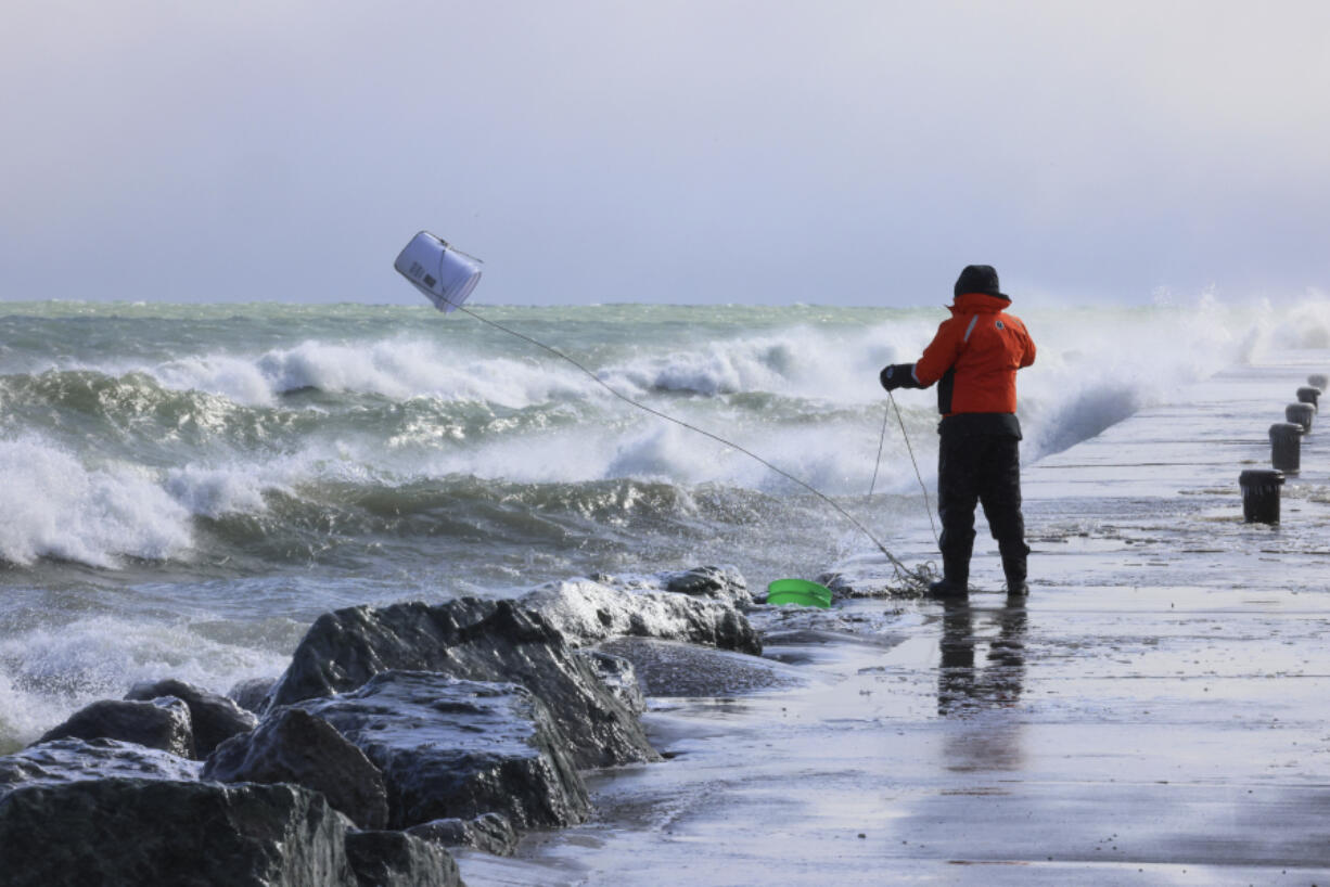 Rae-Ann Eifert, a lake monitor for the Wisconsin Department of Natural Resources,  braved sub-freezing temperatures to gather buckets of water for testing off a Lake Michigan breakwater in Racine, Wis., on Feb. 28, 2024, as part of an effort across the Great Lakes to understand the effects of an iceless winter.  Unseasonable warmth has left the Great Lakes all but devoid of ice, leaving scientists scrambling to understand the consequences as climate change accelerates.