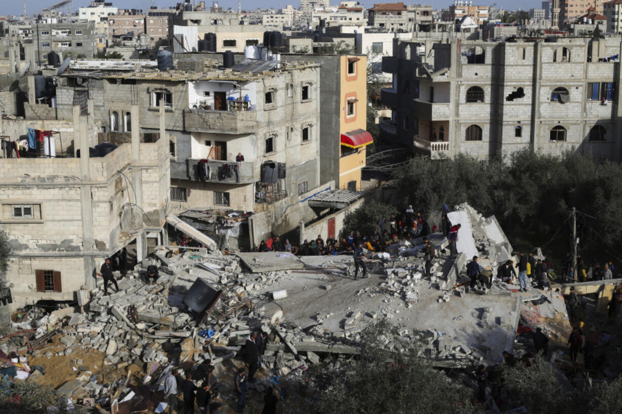 Palestinians look at the destruction after an Israeli strike on a residential building in Rafah, Gaza Strip, Sunday, March 3, 2024.