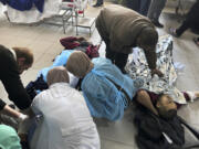 FILE - Palestinians wounded in an Israeli strike while waiting for humanitarian aid on the beach in Gaza City are treated in Shifa Hospital in Gaza City, Feb. 29, 2024. More of President Joe Biden&#039;s top Senate allies are demanding that the U.S. act directly to ease Palestinian civilian suffering in Gaza and are joining calls to cut military aid if Israel refuses to change course.