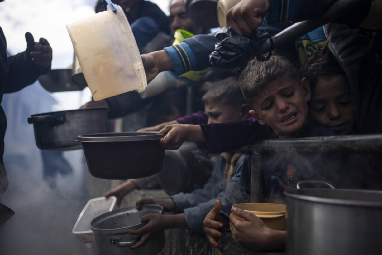 File - Palestinians line up for a free meal in Rafah, Gaza Strip, Friday, Feb. 16, 2024.