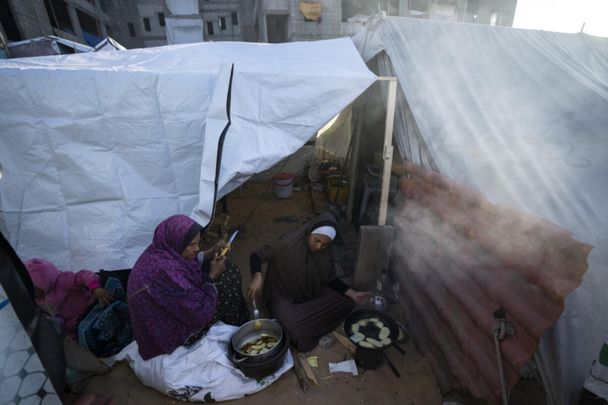 Randa Baker, Right, who was displaced by the Israeli bombardment of the Gaza Strip, prepares the Iftar meal with her mother on the first day of the Muslim holy fasting month of Ramadan at a makeshift tent camp in the Muwasi area, southern Gaza, March 11, 2024. The holy month, typically a time of communal joy and reflection, is overshadowed by the grim reality of a conflict that has claimed over 30,000 Palestinian lives and left vast swaths of Gaza in shambles.