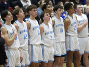 The Mark Morris boys basketball team stands for the national anthem before playing Columbia River in the 2A boys basketball district championship game at Kelso High School on Friday, Feb. 16, 2024.