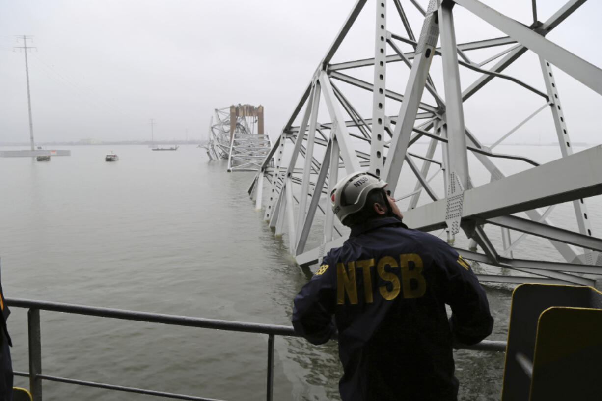 In this image released by the National Transportation and Safety Board, a NTSB investigator is seen on the cargo vessel Dali, which struck and collapsed the Francis Scott Key Bridge, Wednesday, March 27, 2024 in Baltimore.