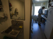 Cheyenne Welbourne is seen March 15 standing at his micro-apartment&rsquo;s kitchenette in the Starlight affordable housing building that is run by Central City Concern, a Portland-based homeless services nonprofit, in Portland.