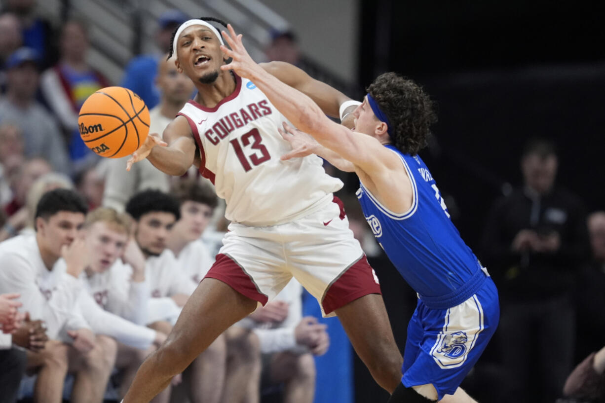 Washington State&rsquo;s Isaac Jones (13) passes around Drake&rsquo;s Conor Enright during the second half of a first-round college basketball game in the NCAA Tournament Thursday, March 21, 2024, in Omaha, Neb.