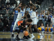 UCLA guard Brandon Williams (5) and UCLA guard Dylan Andrews (2) guard Oregon State guard Jordan Pope (0) during the first half of an NCAA college basketball game in the first round of the Pac-12 tournament Wednesday, March 13, 2024, in Las Vegas.