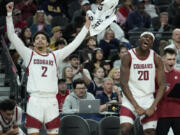 Washington State guard Myles Rice (2) and center Rueben Chinyelu (20) celebrate on the bench as their team defeates Stanford in an NCAA college basketball game in the quarterfinal round of the Pac-12 tournament Thursday, March 14, 2024, in Las Vegas.