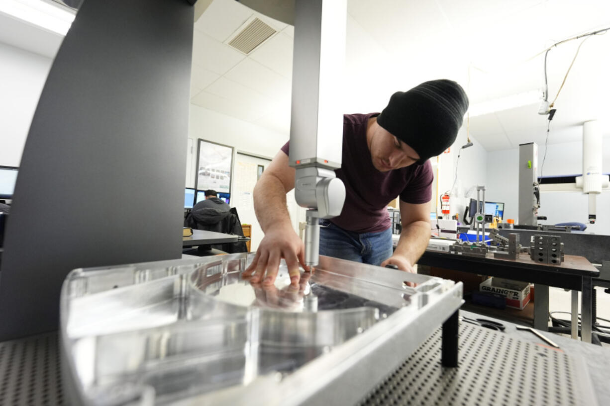 FILE - A worker at Reata Engineering and Machine Works prepares a Hexagon machine used to confirm that parts meet customer standards on Feb.15, 2024, in Englewood, Colo. On Thursday, March 14, 2024, the Labor Department releases producer prices data for February.