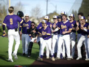 Columbia River players greet Peter Lubisich (9) after the senior hit a solo home run against Ridgefield during a 2A GSHL baseball game on Friday, March 29, 2024, at Ridgefield Outdoor Recreation Complex.