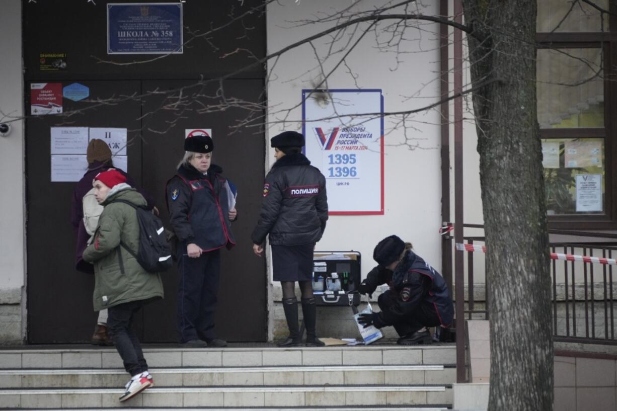 Police officers check the area after a woman threw a Molotov cocktail onto the roof of a school that houses a polling station during a presidential election in St. Petersburg, Russia, Friday, March 15, 2024. Voters in Russia are heading to the polls for a presidential election that is all but certain to extend President Vladimir Putin&rsquo;s rule after he clamped down on dissent.