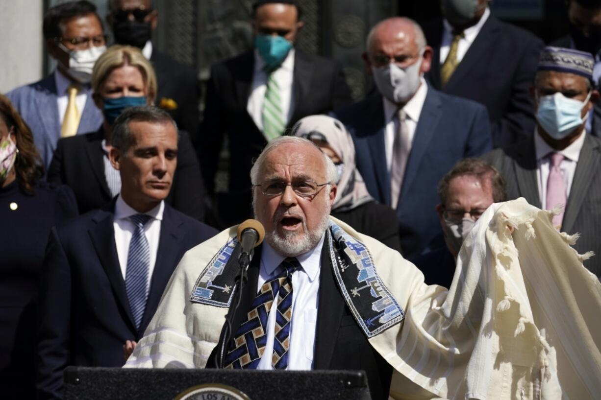 FILE- Rabbi Abraham Cooper, center, of the Simon Wiesenthal Center, speaks in front of civic and faith leaders outside City Hall, Thursday, May 20, 2021, in Los Angeles. A U.S. Congress-mandated group cut short a fact-finding mission to Saudi Arabia over officials in the kingdom ordering a Jewish rabbi to remove his kippah in public, highlighting the religious tensions still present in the wider Middle East.