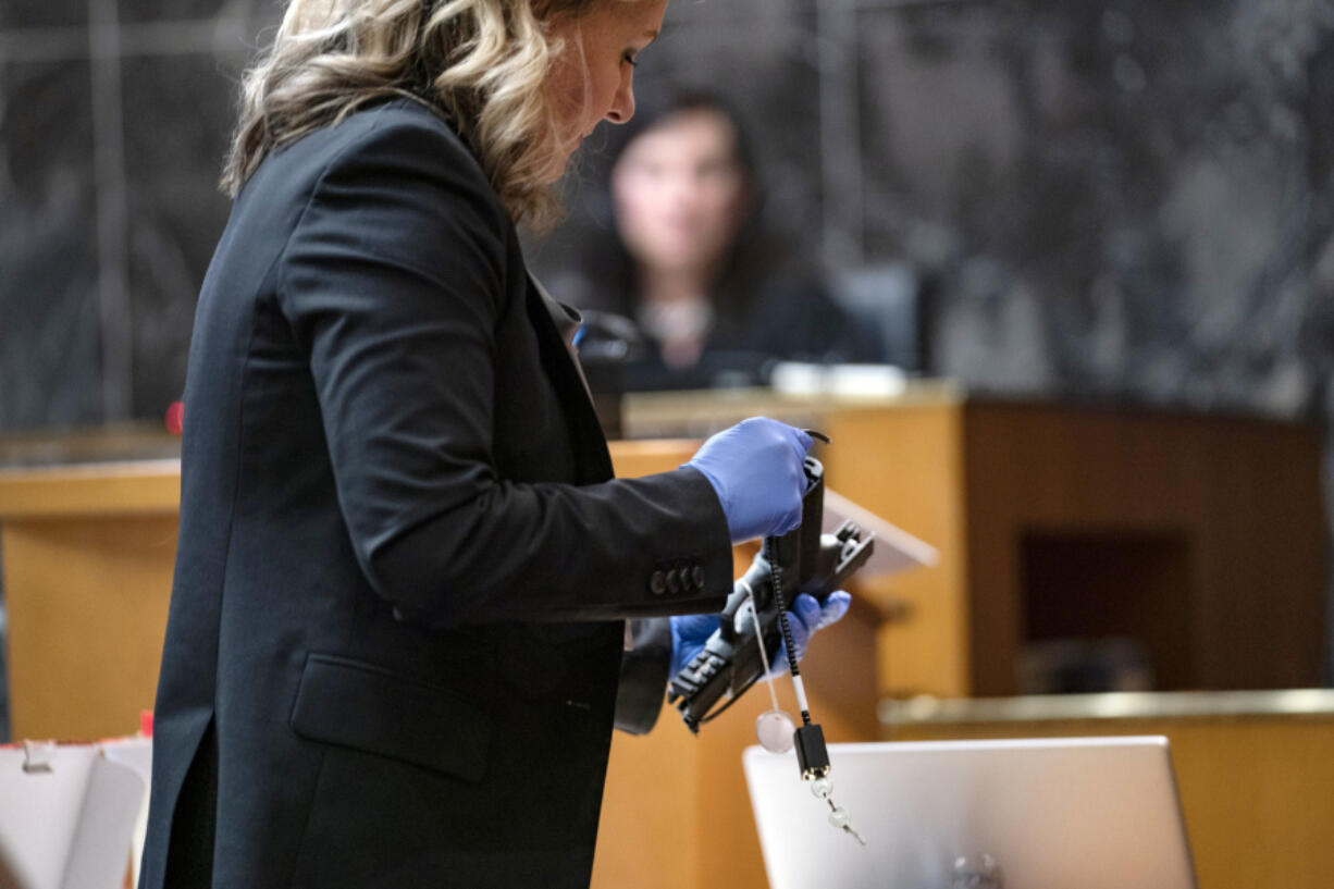 Oakland County Prosecutor Karen McDonald demonstrates how swiftly she was able to insert a gun lock during closing statements in the trial of James Crumbley, Wednesday, March, 13, 2024 in Pontiac, Mich.  Crumbley is charged with involuntary manslaughter, accused of failing to secure a gun at home and ignoring his son&#039;s mental health. Ethan Crumbley killed four students at Oxford High School in 2021.