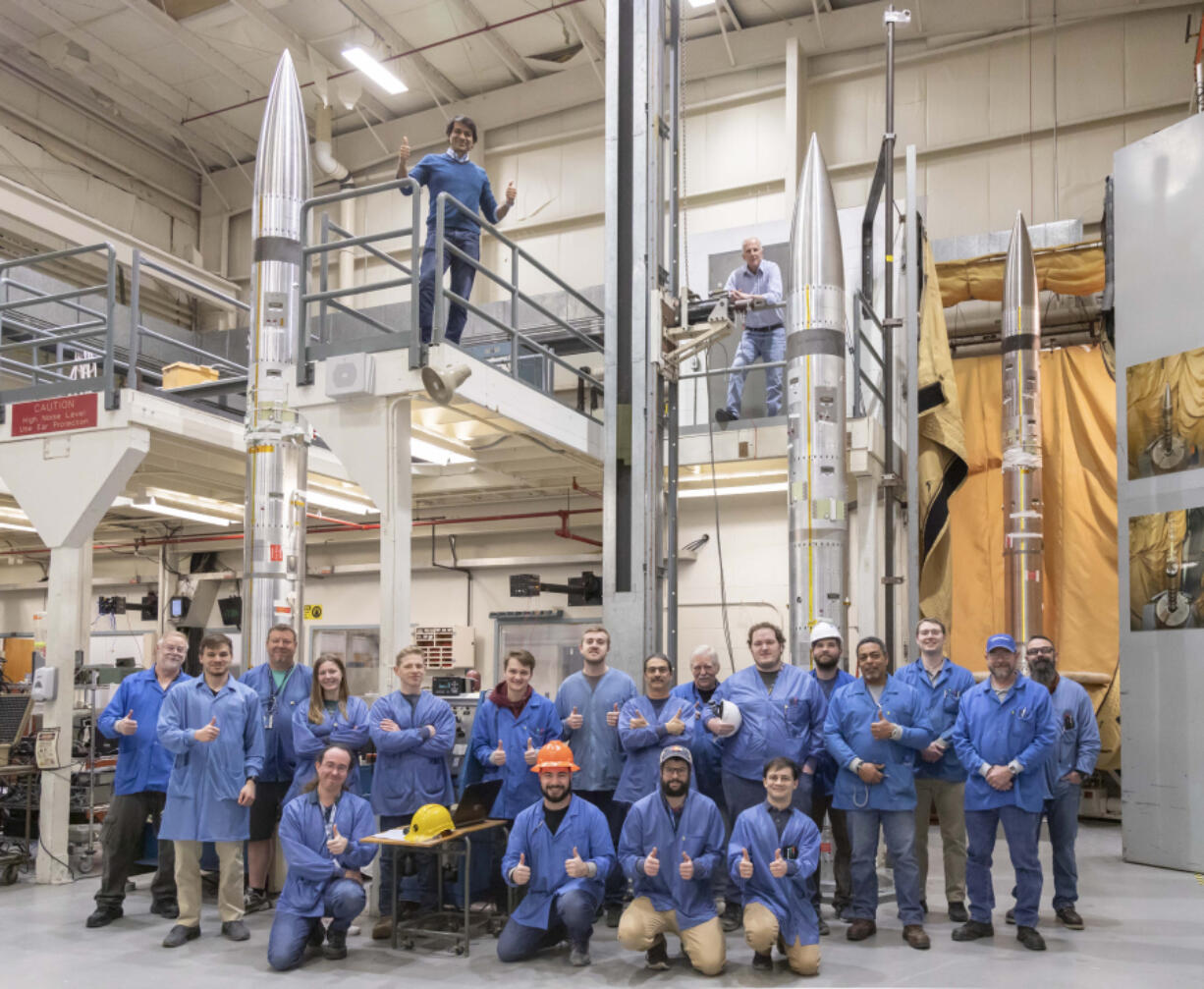 This photo provided by NASA shows three APEP rockets at NASA Wallops Flight Facility on Wallops Island, Va., on Feb. 21, 2024, with Mission Principal Investigator Dr. Barjatya, top left, and NASA Mission Manager Jay Scott, top right, and Embry-Riddle Aeronautical University and NASA personnel. During the April 8, 2024 total solar eclipse, the rockets will blast off with science instruments into the electrically charged portion of the atmosphere near the edge of space known as the ionosphere.