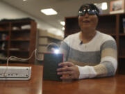 Minh Ha, assistive technology manager at the Perkins School for the Blind tries a LightSound device for the first time at the school&rsquo;s library in Watertown, Mass., on March 2, 2024. As eclipse watchers look to the skies in April 2024, new technology will allow people who are blind or visually impaired to hear and feel the celestial event.