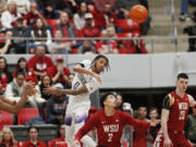 Washington guard Koren Johnson (0) passes the ball next to Washington State guard Myles Rice (2) during the second half of an NCAA college basketball game, Thursday, March 7, 2024, in Pullman, Wash.