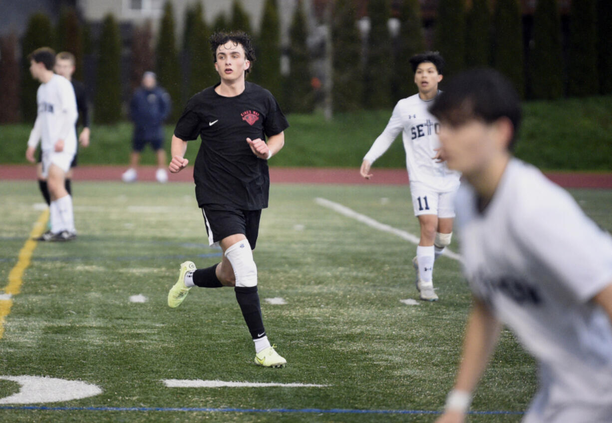 King's Way Christian junior Luke Gomes, left, cuts toward the ball during a boys soccer game against Seton Catholic on March 21 in Vancouver.