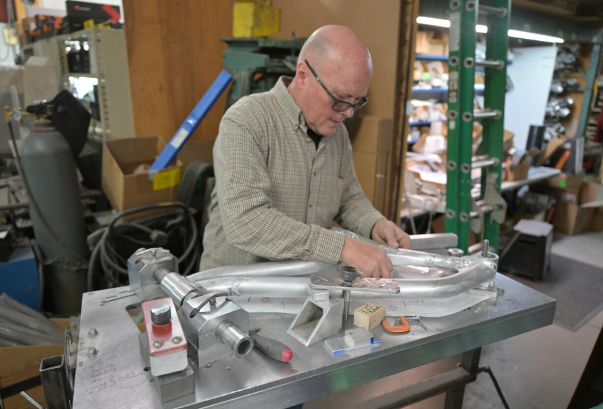 Devin Lenz puts a frame of a full-suspension mountain bike on a welding board at his workshop this week in Fort Lupton. Lenz builds high-performance mountain bikes and ski bikes.