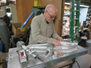 Devin Lenz puts a frame of a full-suspension mountain bike on a welding board at his workshop this week in Fort Lupton. Lenz builds high-performance mountain bikes and ski bikes.