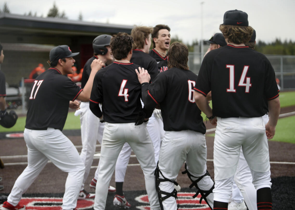 Camas outfielder Jared Forner, center, is mobbed by teammates after hitting a grand slam home run against Battle Ground in the second inning of a 4A Greater St. Helens League baseball game on Thursday, April 11, 2024 at Camas High School.