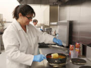 Senior scientist Lisa Humphrey cooks up a batch of Hamburger Helper on March 7 inside of a test kitchen at Eagle Foods Innovation Hub in Buffalo Grove, Ill.