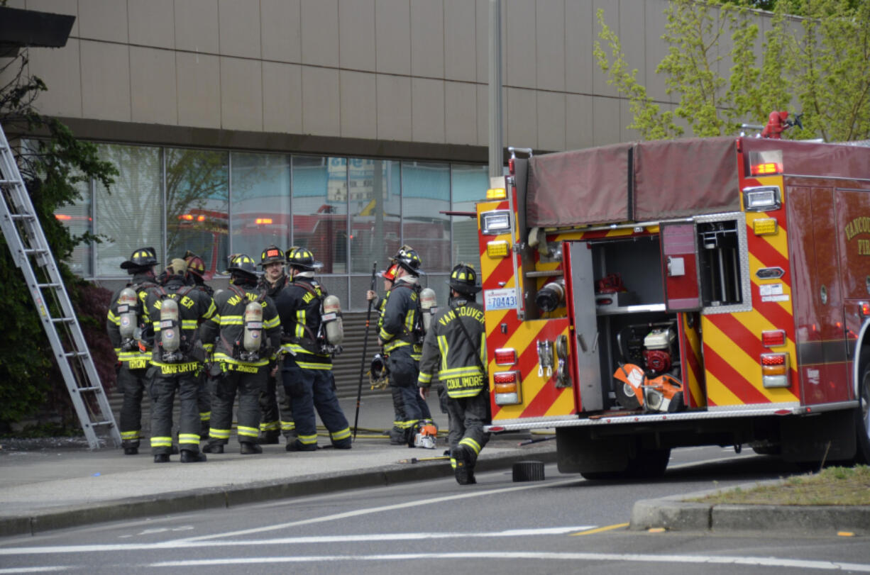 Clark County Fire District 6
Firefighters debrief after extinguishing a small fire in a planter box next to The Columbian&rsquo;s front door on Saturday morning.