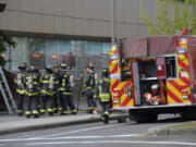 Clark County Fire District 6
Firefighters debrief after extinguishing a small fire in a planter box next to The Columbian&rsquo;s front door on Saturday morning.