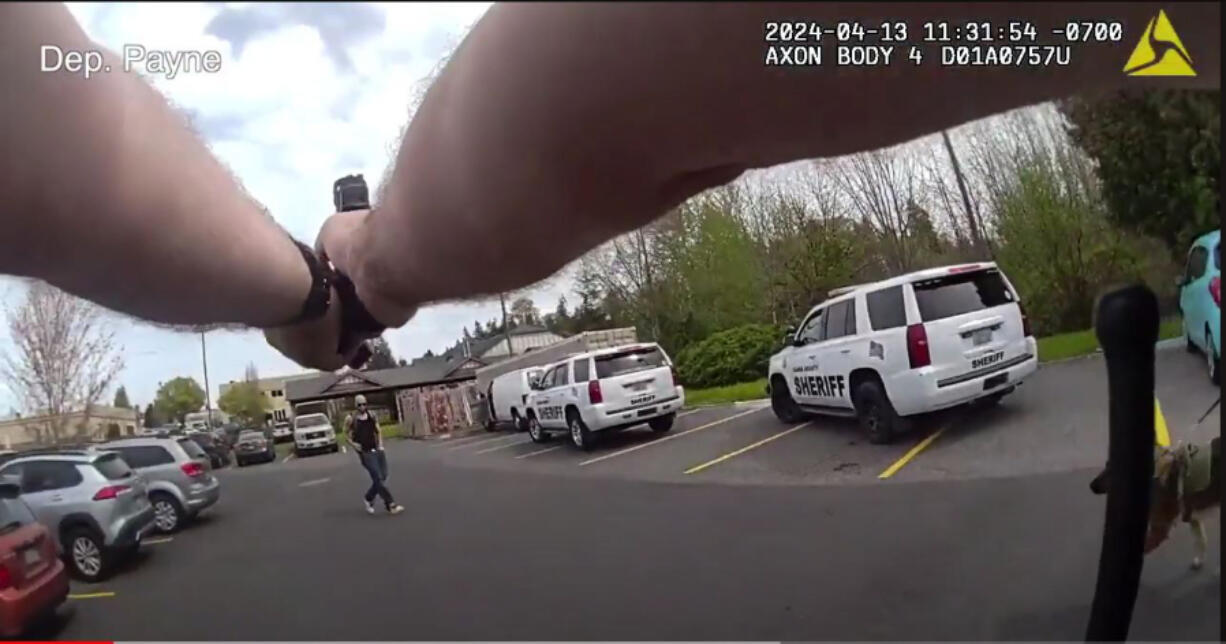 A screenshot from body-worn camera footage in a shooting in Salmon Creek shows Clark County sheriff’s Deputy Jim Payne pointing a weapon at a suspect in carjackings. The suspect pulled a weapon from his pocket.