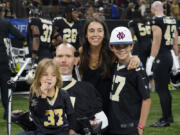 Former New Orleans Saints Steve Gleason poses for a photo with his family before an NFL game against the Tennessee Titans on Sept. 10, 2023.