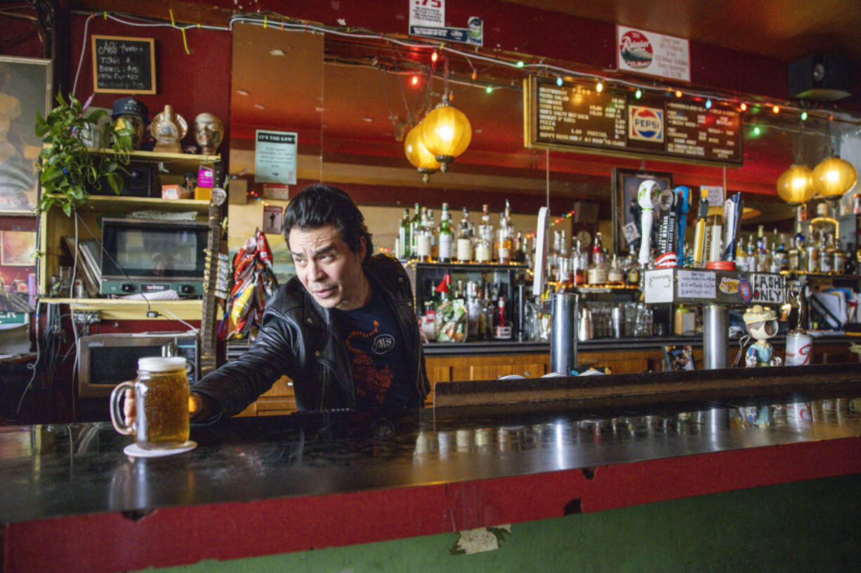 Bar manager Percy Weintraub slides a beer onto the bar for a customer at Al&rsquo;s Tavern in Seattle&rsquo;s Wallingford neighborhood on April 11.