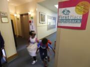 Students walk through a hallway at  First Place Scholars Charter School, Washington's first charter school, in Seattle. Washington’s charter school students are scoring similar or better than their traditional public school peers, according to a new report released by the State Board of Education.