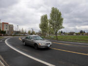 A motorist passes an empty field, right, where a Home2Suites is proposed near Southeast Mill Plain, on Thursday afternoon, April 4, 2024.