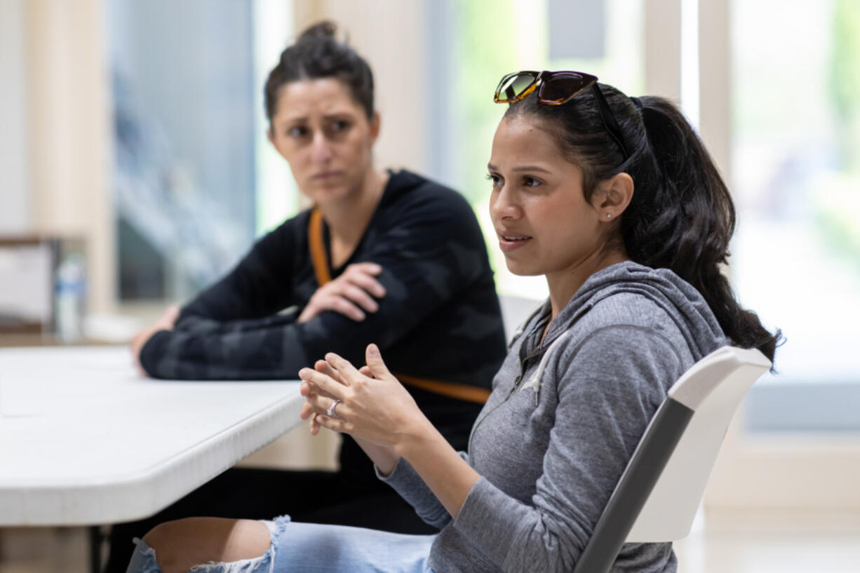 As parent Megan Davis listens, Alicia Johnson discusses her concerns about the proposal to halt enrollment in Hathaway Elementary School&rsquo;s Spanish dual language program with leaders in the Washougal School District on Tuesday.