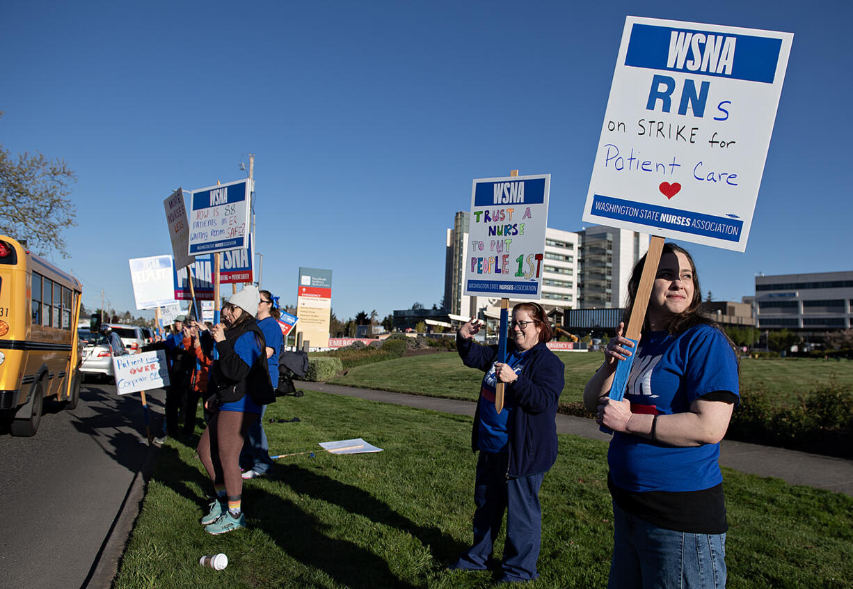 PeaceHealth Southwest Medical Center registered nurse Sarah Collins, right, joins colleagues as they picket outside the hospital on Thursday morning, April 18, 2024.