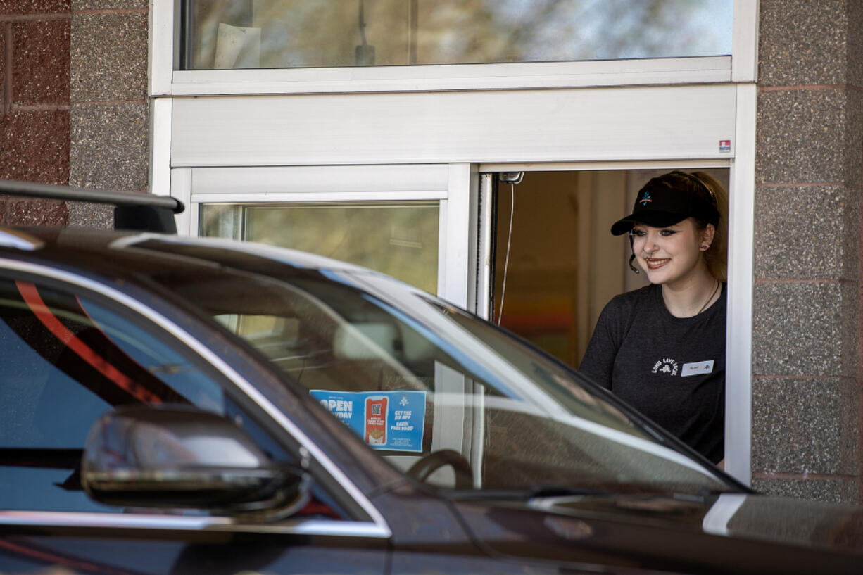 Burgerville crew member Ruby Runnels, 19, greets a customer while working the drive-thru at the restaurant&rsquo;s Salmon Creek location Wednesday afternoon. Several industries in Clark County rely heavily on teens for jobs that peak in demand during the summer. A spokeswoman for Burgerville said the fast-food chain expects to hire 150 additional employees at its Clark County stores between now and July 1.